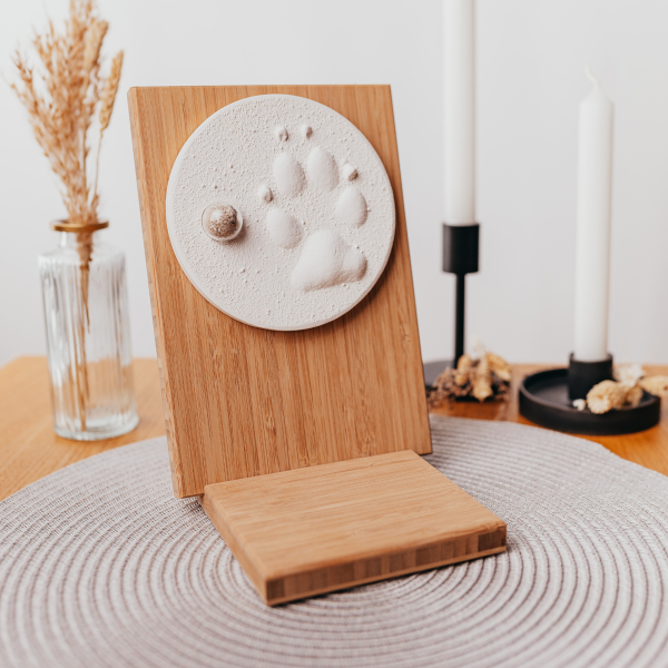 Pfotenabdruck aus Gips mit Asche auf Holztafel